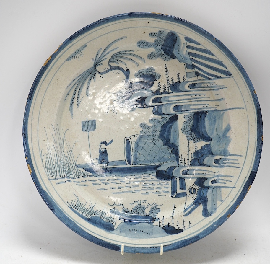 An 18th century Dutch Delft blue and white charger, diameter 33.5cm. Condition - poor, large crack running across half the diameter of the plate and through to the base, as well as some chips to the rim including one lar